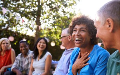 Group Of Mature Friends Socializing In Backyard Together